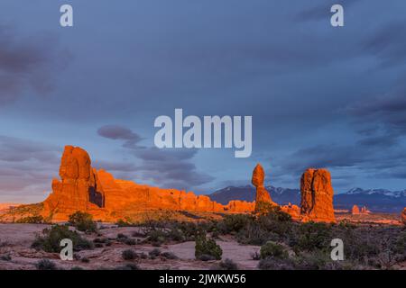 Balanced Rock au coucher du soleil dans le parc national d'Arches près de Moab, Utah. En arrière-plan se trouvent les montagnes de la Sal. Banque D'Images