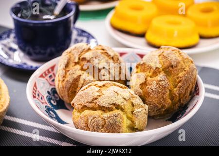 Broa, pain de maïs portugais traditionnel, fait avec du maïs et de la farine de blé, et des sucreries typiques portugaises en arrière-plan, petit-déjeuner européen Banque D'Images