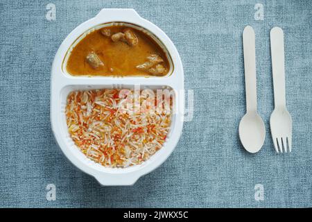 curry de poulet et de riz dans un sachet en plastique à emporter sur la table Banque D'Images