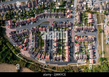 Vue aérienne directement au-dessus d'un nouveau projet de construction de logements à la périphérie d'un village dans un concept d'expansion de logements Banque D'Images