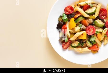 Vue rapprochée de la salade de pâtes à la ratatouille sur l'assiette sur fond clair avec espace de texte libre. Vue de dessus, plan d'appartement Banque D'Images