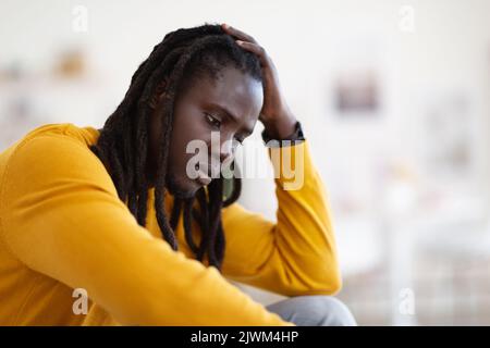 Gros plan Portrait d'un homme afro-américain déprimé assis à la maison Banque D'Images