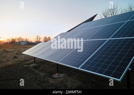 Panneaux photovoltaïques solaires montés sur un cadre autonome sur le sol de l'arrière-cour pour la production d'énergie électrique écologique propre. Concept d'autonomie Banque D'Images