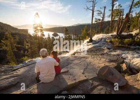 Un homme et une femme apprécient le lever du soleil sur Emerald Bay.