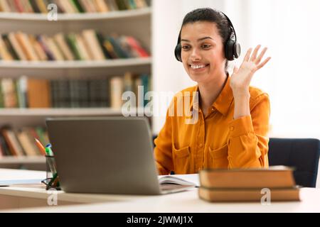 Concept de tutorat en ligne. Bonne race mixte femme tuteur ayant appel vidéo avec les étudiants, en agitant à la webcam d'ordinateur portable Banque D'Images