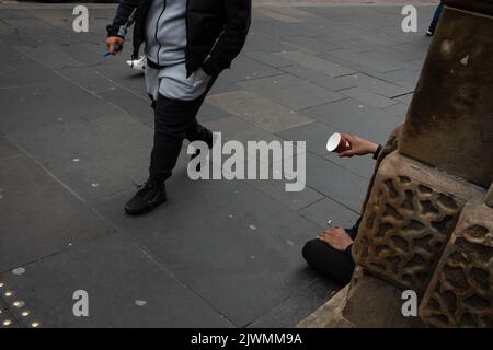 Homme tenant une tasse de café jetable comme il supplie pour l'argent, pendant la crise actuelle du coût de la vie, à Glasgow, Écosse, 6 septembre 2022. Banque D'Images