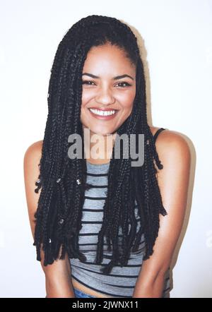 Shes heureux-Go-chanceux. Studio portrait d'une jeune femme attrayante souriant. Banque D'Images