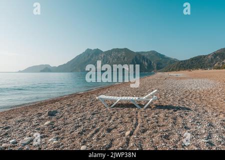 Chaises longues et parasols en rotin sur une plage de sable vide en Turquie Banque D'Images