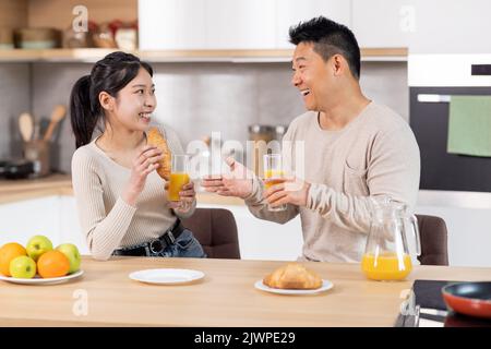 Un bon couple asiatique qui a un en-cas dans la cuisine Banque D'Images