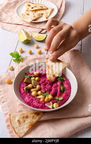 Humus de betterave sur une table en bois blanc Banque D'Images