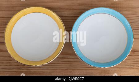 Vue de remorquage o deux petites plaques de céramique sur fond en bois gros plan. Avec des couleurs jaune et bleue sur le bord Banque D'Images