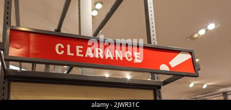 Affiche rouge de liquidation dans le magasin de conservation. Affiches de vente dans un magasin de vêtements. Personne, attention sélective Banque D'Images