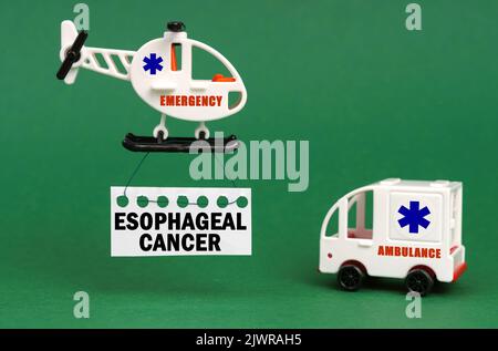 Concept médical. Sur une surface verte, une voiture d'ambulance et un hélicoptère avec un panneau - cancer oesophagien Banque D'Images