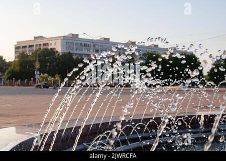 Des éclaboussures d'eau dans la fontaine au coucher du soleil rapprochent Banque D'Images