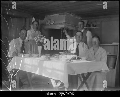 Intérieur inconnu. David Brundin est assis à gauche et son frère Joseph est le deuxième homme avec une cravate. Probablement dans la cuisine du pêcheur à Sikvik. Okänd interiör. David Brundin sitter till vänster och hans bror Josef är den andra mannen med slips. Antagligen i köket hos fiskaren i Sikvik. Banque D'Images