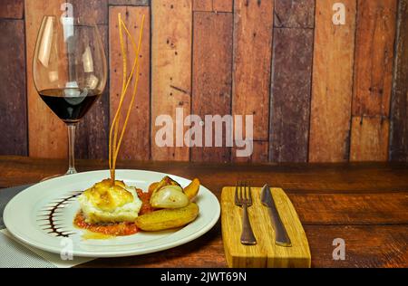 Filet de morue avec gratin au gratin de pomme sauce alioli sur confit de tomate. Banque D'Images