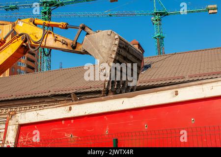 Travaux d'excavation. Le godet du tracteur charge le sol avec une pelle à l'arrière d'un camion-benne sur le chantier. Banque D'Images