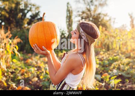 Récolte de citrouilles. Jeune agriculteur cueillant des citrouilles d'automne à la ferme. Agriculture. Thanksgiving et la préparation pour Halloween. La vibration de la chute Banque D'Images