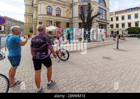 Touristes cyclistes prenant des photos à Szechenyi ter devant le grand MOT SOPRON, Sopron, Hongrie Banque D'Images
