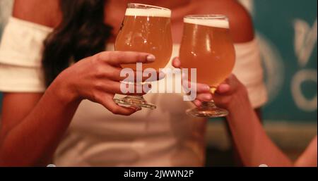 Deux amies qui toastent avec des bières pression Banque D'Images