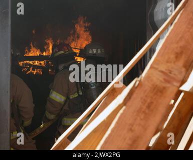 BASE AÉRIENNE DE NIGERIEN 201, Niger - les pompiers de l'escadron 724th de la base aérienne expéditionnaire des pompiers et des services d'urgence effectuent une formation d'incendie de construction en direct à la base aérienne de Nigerien 201, Niger, le 3 septembre 2022. Les pompiers ont passé en revue et pratiqué des compétences de base comme le comportement en cas d'incendie, l'avancement des tuyaux, l'extinction d'incendie et la recherche et le sauvetage. (É.-U. Photo de la Force aérienne par le sergent d'état-major. Alexandra M. Longfellow) Banque D'Images