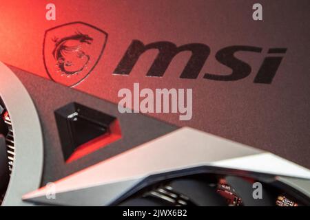 Kiev, Ukraine - 19 août 2022: MSI dragon logo et carte graphique vidéo en lumière rouge, gros plan avec mise au point sélective Banque D'Images