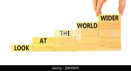 Regardez le symbole du monde entier. Les mots de concept regardent le monde plus large sur des blocs de bois sur un magnifique fond blanc. Main d'homme d'affaires. Entreprise et Banque D'Images