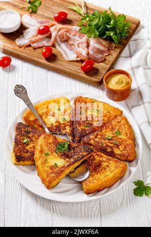 Farls de pommes de terre, gâteaux irlandais de pommes de terre, pain de pommes de terre sur plaque blanche sur table en bois blanc avec bacon, tomates et persil en arrière-plan, vue verticale Banque D'Images