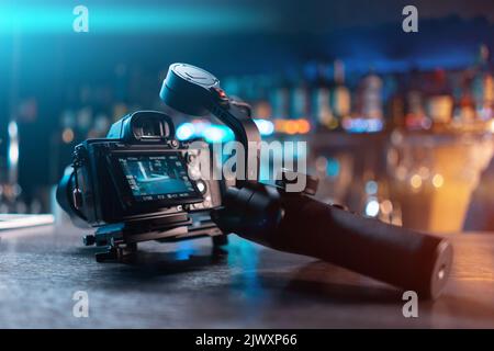 nacelle vidéo portable avec appareil photo reflex numérique sans miroir sur table en bois Banque D'Images