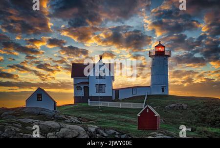 Lever du soleil tôt le matin au-dessus du phare de Nubble, York, Maine. Banque D'Images