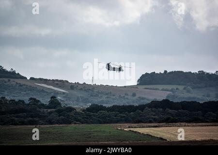 Hélicoptère CH-47 à rotor tandem RAF Chinook volant rapidement et bas dans un ciel bleu ciel gris nuageux lors d'un exercice de bataille militaire, Wilts UK Banque D'Images