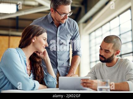 Faire des tombeaux de succès aujourd'hui. Un groupe de collègues ayant une réunion dans un bureau ouvert plan. Banque D'Images