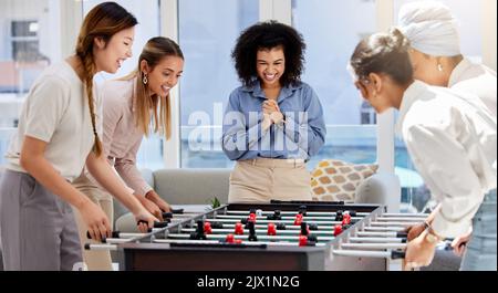 Les femmes en voyage d'affaires, de pause et de travail jouent au jeu dans le salon de bureau et s'amusent et se rassemblent. Tendance, cool et diversité de la créativité Banque D'Images