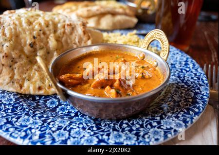 Cuisine de style indien, plat de cari chiken tikka masala servi avec du riz et du pain naan à l'ail, gros plan Banque D'Images