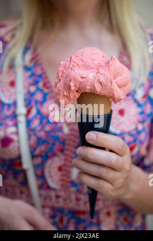 Femme tenant de la glace aux fruits vegan dans un cornet de gaufres dans la rue, gros plan Banque D'Images