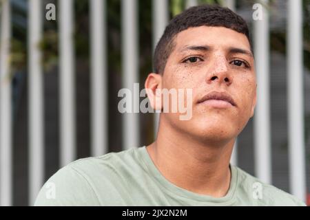 Portrait d'un jeune homme vêtu de vert et regardant l'appareil photo. Banque D'Images