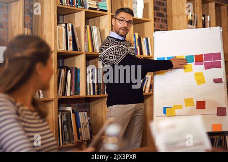 Nous devons travailler à chaque étape du processus, un homme d'affaires qui donne une présentation dans la salle de réunion. Banque D'Images