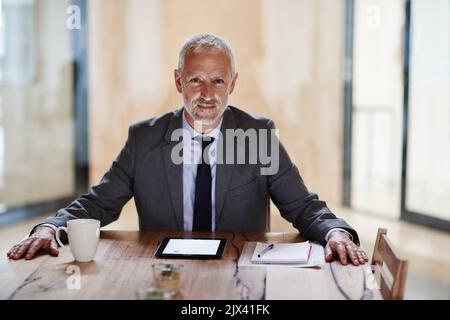 Utiliser la technologie pour construire son empire. Un homme d'affaires utilisant une tablette numérique. Banque D'Images