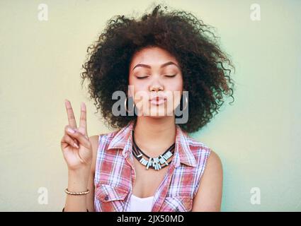 Paix et Silence s'il vous plaît. une jeune femme attrayante montrant le signe de la paix. Banque D'Images