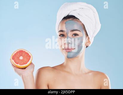 Femme, soin de la peau et masque de pamplemousse, beauté organique et bien-être pour un antivieillissement sain, détox frais et visage naturel propre sur fond bleu Banque D'Images