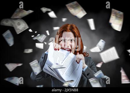 Jeune femme stressée déchirant des documents avec une expression faciale frustrée. Banque D'Images