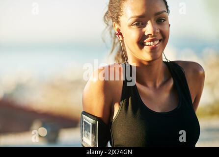 La forme physique met toujours un sourire sur mon visage. Une jeune femme s'exerçant à l'extérieur. Banque D'Images