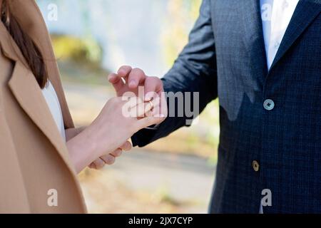 Je me Marie aujourd'hui et chaque jour, les mains d'un couple hétérosexuel de mariage. Le marié a mis l'anneau sur le doigt de sa belle femme. Mise au point sélective douce Banque D'Images