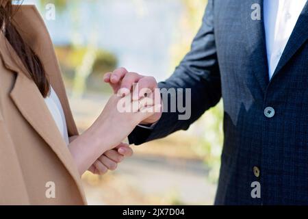 Je me Marie aujourd'hui et chaque jour, les mains d'un couple hétérosexuel de mariage. Le marié a mis l'anneau sur le doigt de sa belle femme. Mise au point sélective douce Banque D'Images