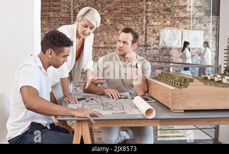 Un architecte, un constructeur et un ingénieur se rencontrent et travaillent en équipe dans un bureau avec un plan et une planification dans l'industrie de la construction. Travail d'équipe et Banque D'Images