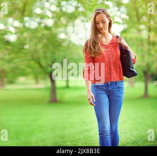 Un beau jour d'été, une jeune femme qui marche dans un parc. Banque D'Images