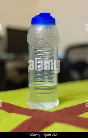 Une grande bouteille d'eau en plastique conservée sur un lit. Banque D'Images