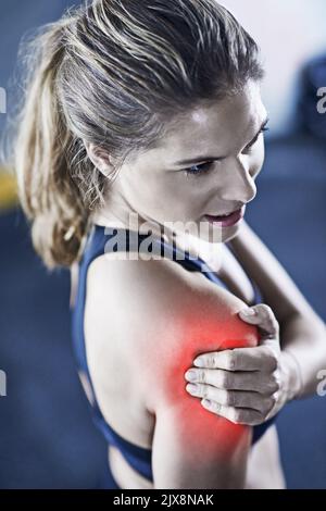 La plaie est la douleur la plus satisfaisante. Une jeune femme qui tient ses épaules blessées est mise en évidence en rouge. Banque D'Images