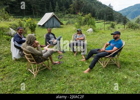 17 septembre 2021 Himalaya Uttarakhand Inde. Un groupe de campeurs se détendant ensemble sur un camping entouré de montagnes et de forêt de déodar. Banque D'Images