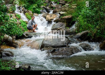 17 septembre 2021 Himalaya Uttarakhand Inde. Un homme qui profite d'un cours d'eau qui coule dans les collines de l'Himalaya. Banque D'Images